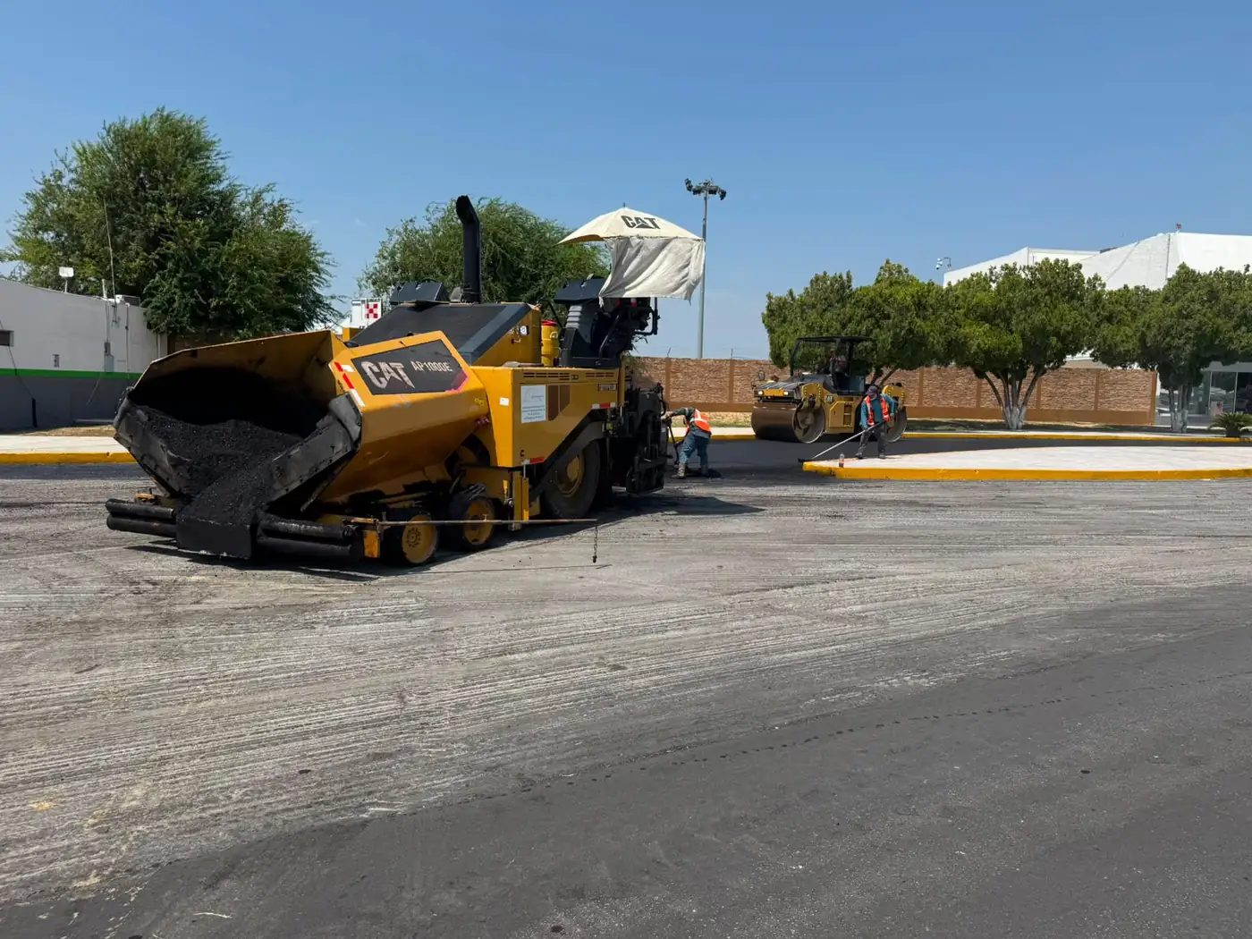 Pavimentadora tendiendo carpeta asfáltica en el estacionamiento